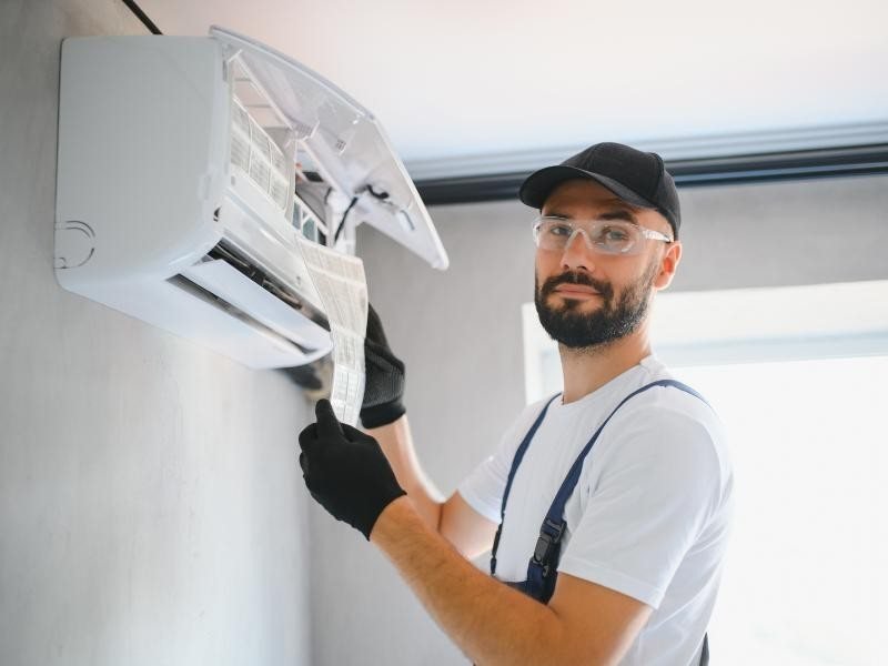 Técnico realizando manutenção em ar-condicionado split